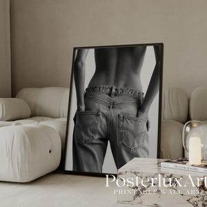 May include: Black and white framed print featuring a person's back in jeans with hands in pockets. The print is leaning against a wall. The text "Posterlux Art" is visible at the bottom.