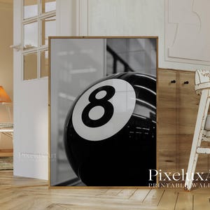 May include: Black and white framed print featuring a close-up of a glossy eight ball. The number eight is prominently displayed in white against the black surface of the ball. The print is a modern wall art piece.