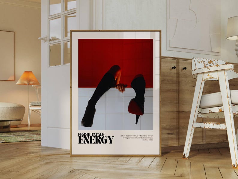 May include: Framed art print featuring a striking image of legs and high heels against a red backdrop. The print includes the words "FEMME FATALE ENERGY" in bold text, with additional text below. The artwork is displayed in a room with wooden floors.