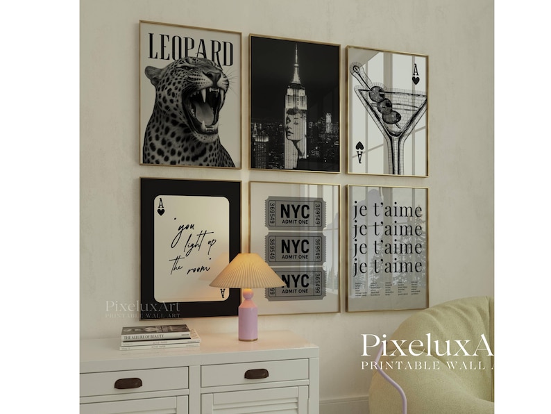 May include: A collection of framed wall art with gold frames. The prints feature a leopard, the Empire State Building, a martini, playing cards, NYC tickets, and the phrase "je t'aime". The text "you light up the room" is also visible.