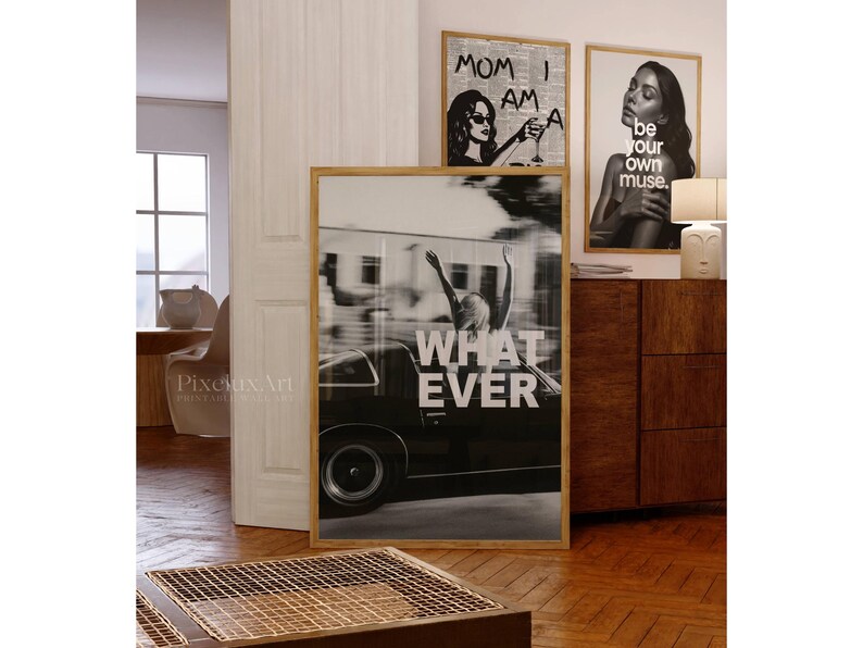 May include: A selection of framed art prints in a contemporary style. One print shows a person in a car with the text "WHATEVER". Other prints feature a woman with the text "MOM I AM A" and a portrait with the text "be your own muse."