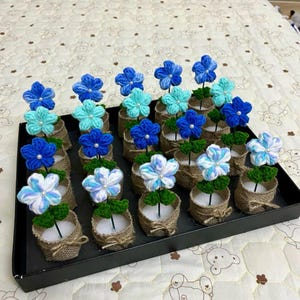 May include: A white ceramic mug with a black handle and the text "But First, Coffee" in a black, handwritten-style font. The mug is on a white surface.