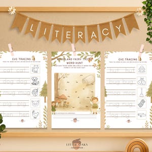 Op de afbeelding: Een houten lijst met drie educatieve werkbladen voor kinderen. De werkbladen zijn met roze wasknijpers op een prikbord gespeld. De bovenste banner luidt "LITERACY". De werkbladen bevatten CVC-tracing en een bosfee&euml;nwoordenjacht.