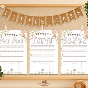 Puede incluir: Imprimibles educativos para niños con las letras A, T y S. Cada hoja tiene letras mayúsculas y minúsculas con líneas de trazado. La pancarta de arriba dice "LITTLE OAKS". Las hojas se muestran en un marco de madera.