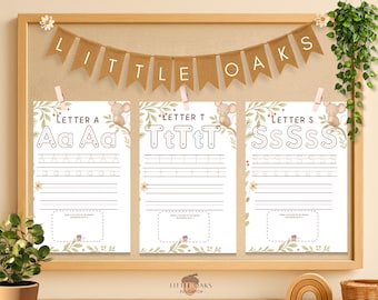 Op de afbeelding: Educatieve printables voor kinderen met de letters A, T en S. Elke pagina heeft hoofdletters en kleine letters met traceerlijnen. De banner hierboven luidt "LITTLE OAKS". De pagina's worden weergegeven in een houten frame.