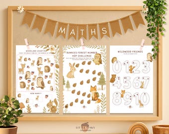 Op de afbeelding: Een educatieve printset met houten frame met drie pagina's. De banner hierboven luidt "MATHS". De pagina's bevatten illustraties van bosdieren en cijfertraceeractiviteiten. De tekst op de pagina's bevat "Woodland Counting", "Bunnies Forest Number Hop Challenge" en "Wildwood Friends".