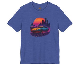 Könnte beinhalten: Ein blau meliertes Kurzarm-T-Shirt mit einem Grafikdruck eines Sportwagens, der auf einer Gitteroberfläche fährt. Der Hintergrund zeigt eine große orangefarbene und gelbe Sonne, Palmen und eine dunkle Skyline einer Stadt in lebendigen Farben.