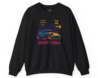 May include: Black sweatshirt with a retro racing car graphic. The design features a blue and yellow car with the text "INSERT COIN" and a game interface with the score, lap, and time displayed. The sweatshirt has a crew neck and long sleeves.
