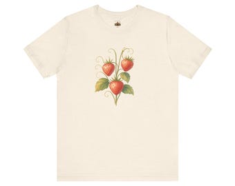 May include: A cream-colored short-sleeve t-shirt featuring a central graphic illustration of three red strawberries on a green vine with leaves and curling tendrils. The design is positioned on the chest area of the garment.
