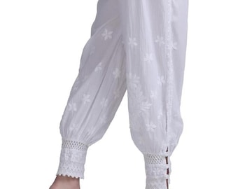 May include: White cotton pants with floral embroidery and a gathered ankle. The pants feature a lace trim at the ankle and a button detail. The fabric appears lightweight and breathable.