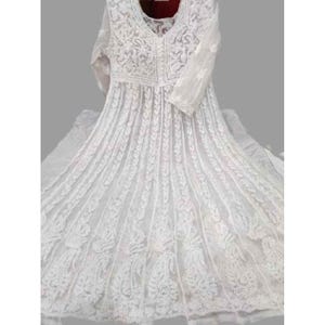 May include: A white, long-sleeved dress with intricate embroidered detailing. The dress features a V-neckline and a flowing skirt, showcasing a delicate, lacy pattern. The embroidery is visible across the bodice and sleeves, creating a textured, elegant look.