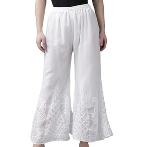 May include: White palazzo pants with intricate embroidered floral patterns near the hem. The wide-leg pants have a comfortable, flowing design. The pants are made of a lightweight fabric, perfect for warm weather.