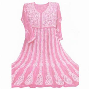 May include: A pink, long-sleeved dress with intricate white embroidery. The dress features a V-neckline and a flowing skirt. The embroidery includes floral and paisley patterns, creating a delicate and detailed design. The dress is made of a lightweight fabric.