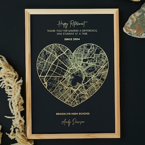 May include: A framed print with a black background and a gold heart-shaped map. The text "Happy Retirement" and "Since 2004" are at the top. The bottom reads "Brooklyn High School" and "Andy Dawson."