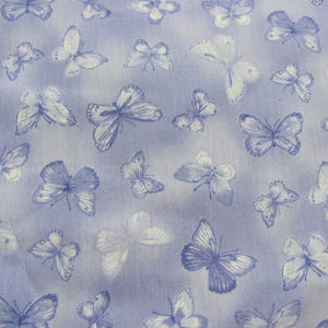May include: A fabric featuring a pattern of blue and white butterflies. The butterflies are of different sizes and are spread across a pale blue background. The butterfly wings have detailed markings.