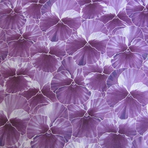 Könnte beinhalten: Ein nahtloses Stoffmuster mit einem sich wiederholenden Muster aus violetten Stiefmütterchen mit weißen Akzenten. Die Stiefmütterchen sind in einem engen, überlappenden Muster angeordnet.