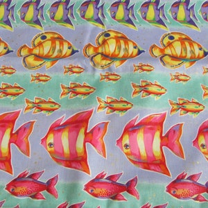 May include: A colorful fabric with a repeating pattern of fish. The fish are in shades of pink, orange, yellow, and purple. The background is a light blue with a green and white watercolor effect.