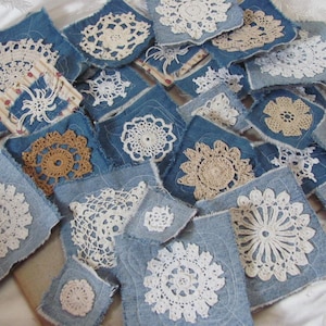 May include: A collection of square denim fabric patches, each featuring a unique white or beige crocheted lace doily centered on the material. The denim squares have frayed edges and visible stitching, showcasing a variety of intricate floral and geometric patterns in different sizes.