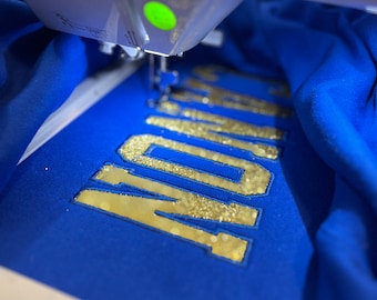 Camiseta de manga larga con apliques de purpurina: bordado con espíritu escolar