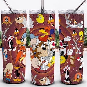 May include: Three stainless steel tumblers with a maroon background, adorned with Looney Tunes characters. Each tumbler has a straw and a clear lid. The Looney Tunes logo is displayed on the side.