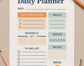 May include: A white daily planner with the title "Daily Planner" in navy blue. The planner includes sections for top priorities, meals, water intake, notes, and a to-do list. Coloured pencils in green, orange, pink, and blue surround the planner.