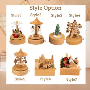 May include: A collection of seven wooden music boxes labeled Style 1 through Style 7. The designs include a snowflake carousel, a ballerina carousel, a Christmas tree, a Ferris wheel, a horse carousel, a mountain train scene, and a holiday village.
