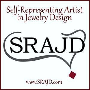 May include: Logo for a jewellery design company called "SRAJD", which stands for "Self-Representing Artist in Jewellery Design". The logo is a stylised wordmark in black with a grey curved line around it. The website address "www.SRAJD.com" is displayed below the logo.