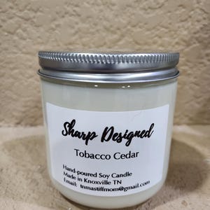 Sharp Designed hand poured soy candle with a wood wick. Tobacco Cedar.