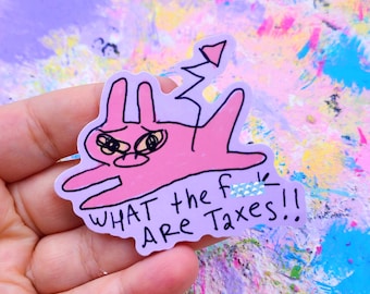 May include: A pink sticker featuring a cartoon bunny with an angry expression and a devil tail. The sticker has the text "WHAT the f ARE Taxes!!" in black font.