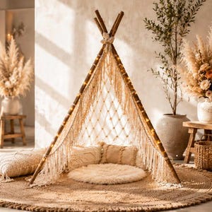May include: A beige macrame teepee tent with wooden poles, positioned on a round woven jute rug. The interior features a circular floor cushion and rectangular pillows. Text includes DrdesignHazineleri, Boho Teepee, and other phrases.