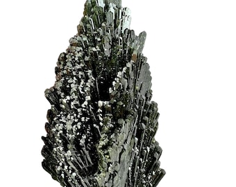 May include: A dark green mineral specimen with a crystalline structure. The mineral has a cluster of needle-like crystals, with a slightly reflective surface. The overall shape is irregular, with a rough texture. The mineral is set against a white background.