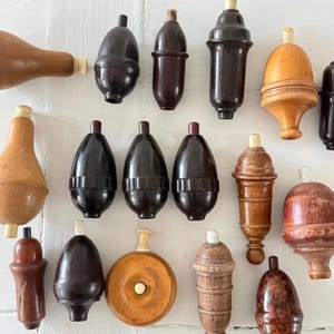 Peut inclure: Une collection de bouchons de bouteilles en bois de différentes teintes de marron, allant du beige clair au acajou foncé. Les bouchons présentent des formes diverses, notamment bulbeuses, cylindriques et en forme de champignon. Certains ont un dessus blanc ou crème contrastant.