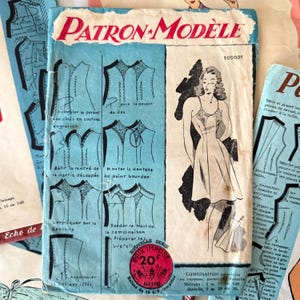Puede incluir: Patrón de costura francés vintage titulado "PATRON + MODELE" con ilustraciones y texto. La portada presenta un dibujo de una mujer con un vestido e instrucciones. El patrón incluye diagramas y texto en francés.