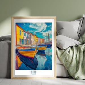 May include: A framed art print showing a vibrant waterfront scene. The image features boats moored along a canal, with buildings in the background. The boats are yellow and blue, and the buildings are painted in various bright colours. The sky is blue with white clouds.