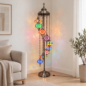 May include: A tall floor lamp with a dark bronze metal stand and a circular base. It features nine hanging mosaic glass globes in various colors including blue, green, orange, red, and yellow, arranged in a spiral pattern around the central pole.