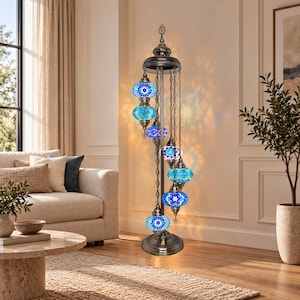 May include: A tall floor lamp with a dark bronze metal stand and seven hanging mosaic glass globes in various shades of blue and turquoise. The globes are suspended at different heights by chains from a central top decorative finial.