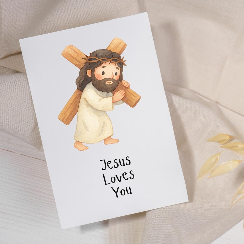 Puede incluir: Una tarjeta de felicitaci&oacute;n blanca con una ilustraci&oacute;n en acuarela de una figura con cabello casta&ntilde;o y barba, vistiendo una t&uacute;nica color crema y una corona de espinas, cargando una cruz de madera. El texto "Jesus Loves You" est&aacute; impreso en negro.