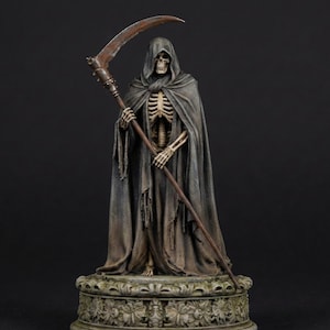 May include: A detailed figurine of a skeleton figure draped in a weathered, dark grey hooded cloak. The figure holds a long, rustic scythe with a rusted blade. It stands upon a circular, ornate stone-like base featuring intricate floral carvings.