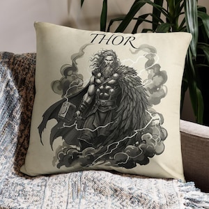 May include: A decorative throw pillow featuring a black and white illustration of Thor, holding a hammer, surrounded by clouds and lightning. The word "THOR" is printed above the image.