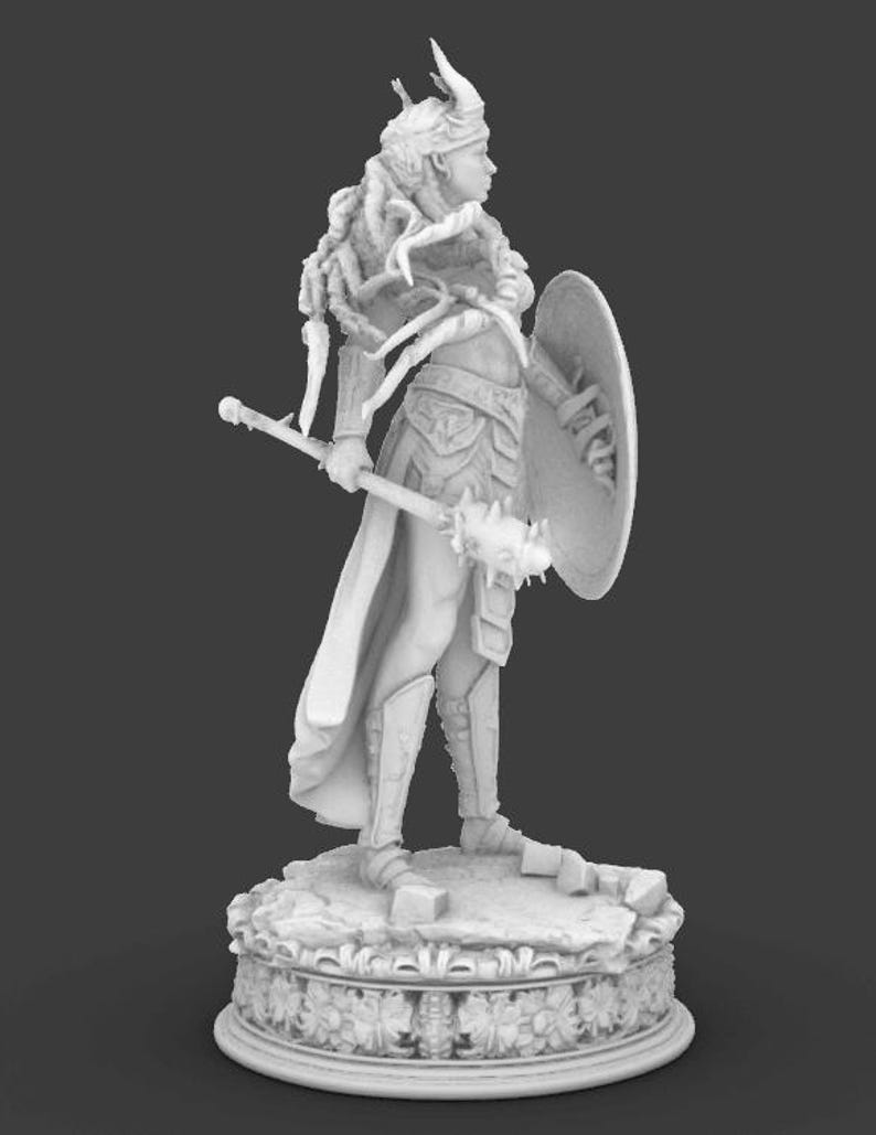 May include: A monochrome figurine of a warrior woman, holding a mace and shield, and wearing armour. The figure stands on a decorative base, with detailed design. The warrior is in a side profile pose, showcasing the intricate details of the figure.