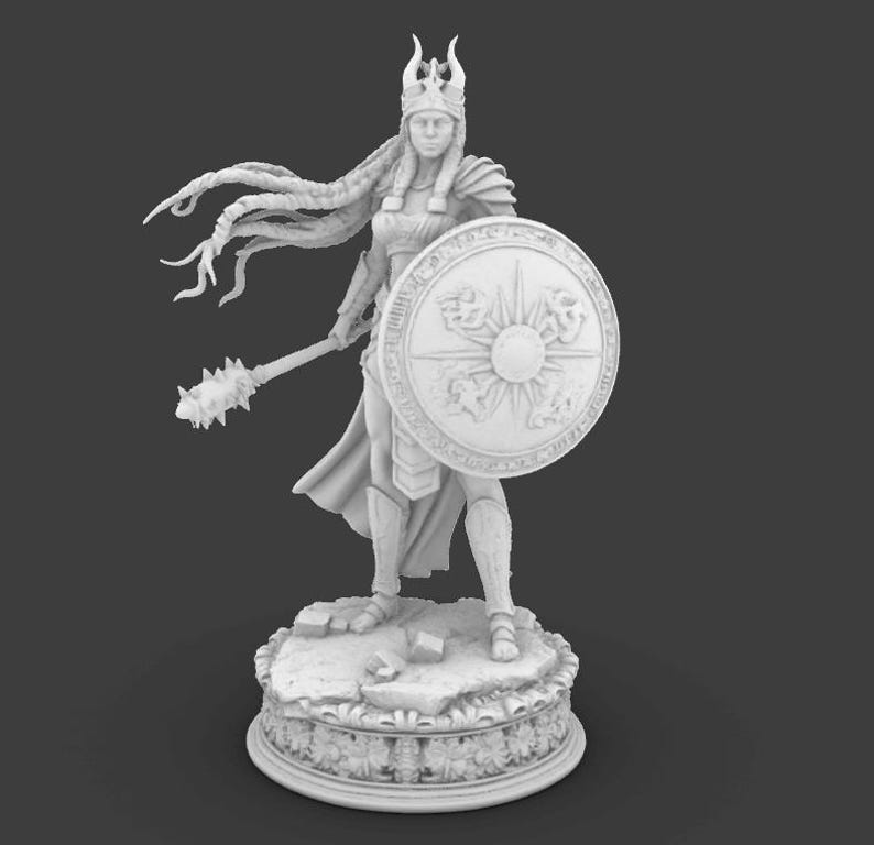 May include: A white figurine of a warrior woman, holding a mace and shield. The shield features a sunburst design. The figure is adorned with a crown and armor, standing on a detailed base. The statue is approximately 25 cm tall.