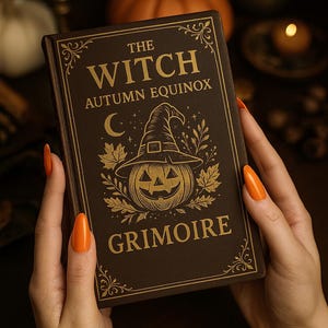 May include: A brown book titled "The Witch Autumn Equinox Grimoire" with gold lettering and illustrations of a witch hat, pumpkin, and moon. The book is held by a person with orange nails.