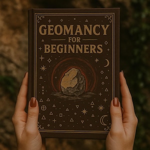 May include: A brown book titled "Geomancy for Beginners" with a stylized illustration of a rock formation inside a circle. The cover features geometric shapes and celestial symbols. The book is held by hands with red nail polish.