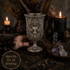 May include: A silver-toned goblet featuring a relief sculpture of a figure emerging from a lotus flower, holding two lotus blossoms. The base is decorated with a small lotus motif. Text on the image reads: digital file for 3d printing.