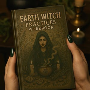 May include: A hardcover book titled "Earth Witch Practices Workbook" is held in front of a blurred background. The cover features an illustration of a woman in a green hooded cloak, a cauldron, candles, and the book's title in gold lettering.