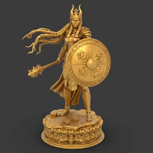 May include: A gold statue of a female warrior, holding a mace and shield. The shield has a sun design. The statue stands on a detailed base with floral patterns. The warrior wears a crown and armour.