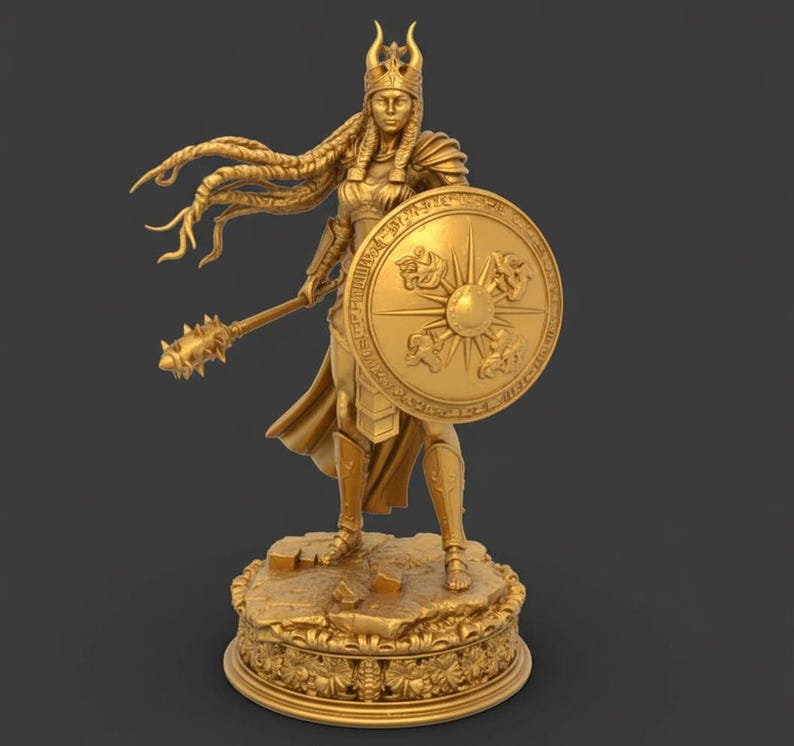 May include: A gold statue of a female warrior, holding a mace and shield. The shield has a sun design. The statue stands on a detailed base with floral patterns. The warrior wears a crown and armour.