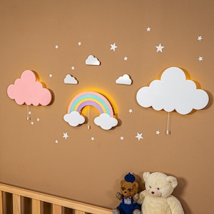 May include: A whimsical wall decor set featuring a rainbow, clouds, and stars in pastel colors. The set includes a pink cloud, a rainbow with pastel arches, and white clouds. The decor is designed to create a cheerful atmosphere.