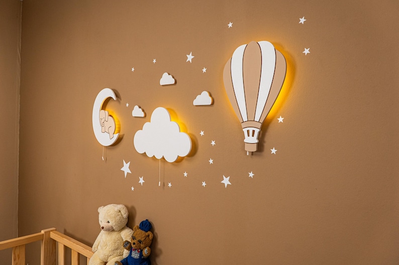 Wooden nursery wall decor set with hot air balloon, glowing cloud and crescent moon night lights for baby room, warm LED Montessori nursery lighting made from plywood, Scandinavian style neutral beige wall decoration for toddler bedroom, handcrafted baby nursery lamp set with stars and clouds, soft ambient lighting for newborn room, modern kids room wall art with illuminated balloon and moon design.