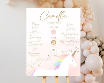 May include: A pink and gold printable first birthday sign with a unicorn illustration. The sign includes the name Camille, the child's weight, age, and favorite songs and books. The sign is decorated with gold glitter and stars.